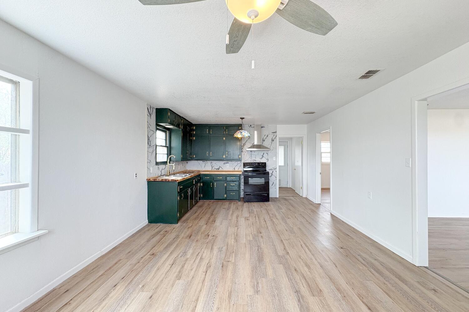 809 West 5th Street Wolfforth, TX 79382 - Photo 7 of 23 a large kitchen with a wooden floor and stainless steel appliances