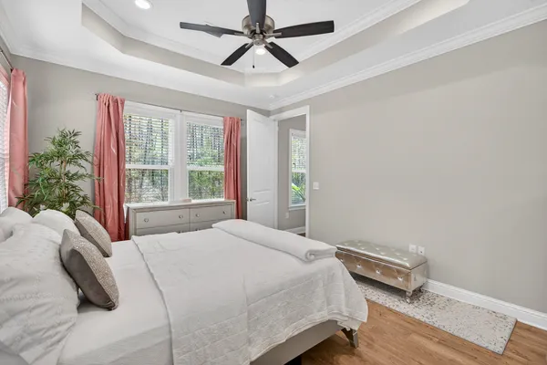 a bedroom with a bed a chandelier and a window