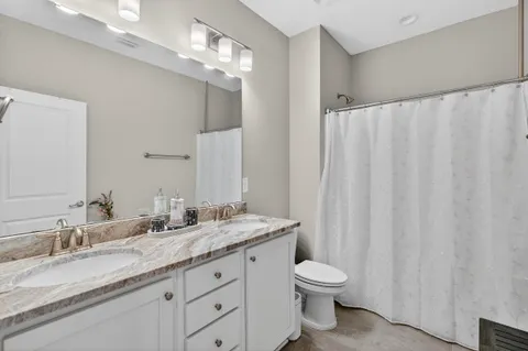 a bathroom with a granite countertop sink a toilet and a mirror