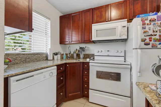 a kitchen with granite countertop cabinets stainless steel appliances and a sink