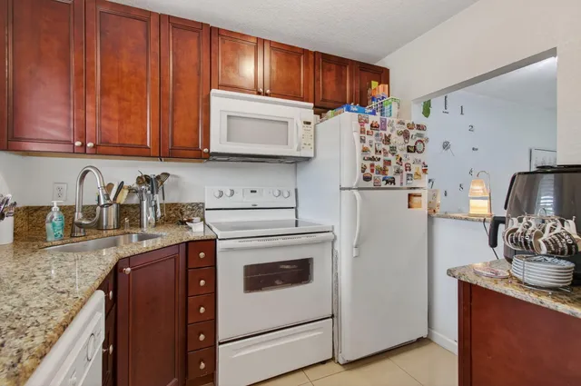 a kitchen with stainless steel appliances granite countertop a refrigerator stove and sink