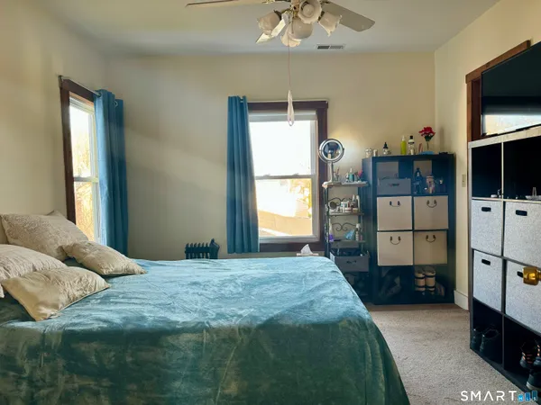 a bedroom with a bed and a flat tv screen on dresser