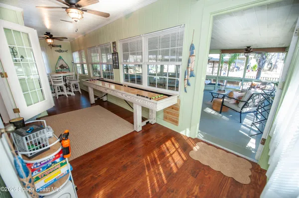 a kitchen with a wooden floor and chairs