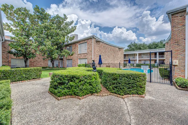 a view of a house with a yard and potted plants