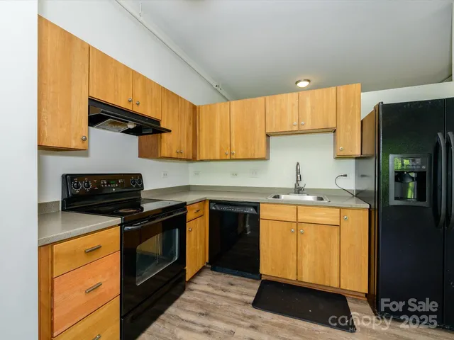 a kitchen with stainless steel appliances granite countertop a stove a sink and a refrigerator