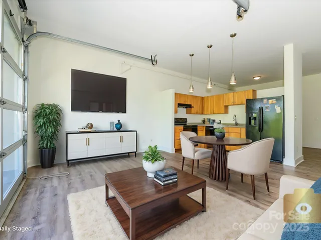a living room with furniture a flat screen tv and a large window