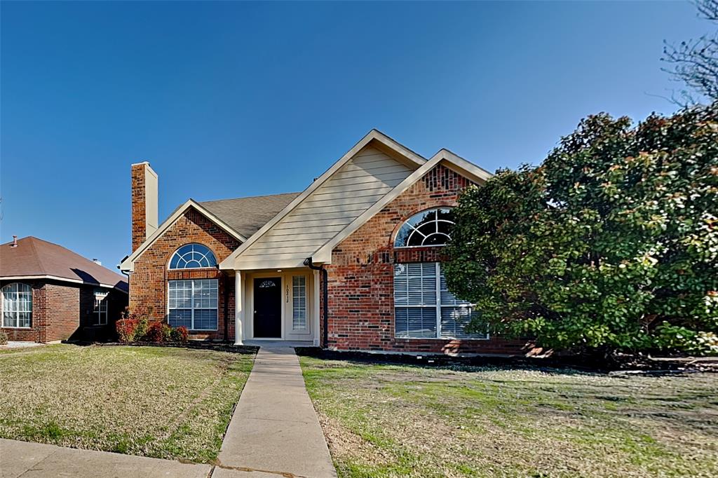 Traditional-style house featuring brick siding, a chimney, and a front yard