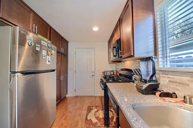 a kitchen with stainless steel appliances granite countertop a stove microwave and sink
