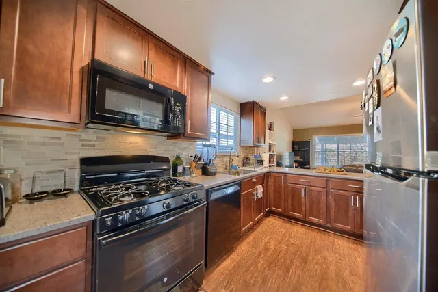 a kitchen with stainless steel appliances granite countertop a refrigerator and a sink