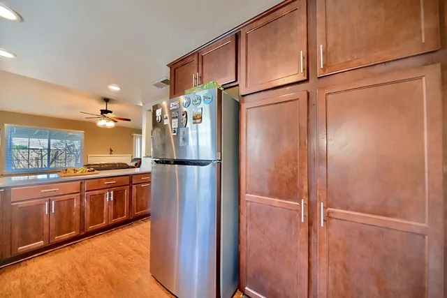 a kitchen with kitchen island granite countertop a sink cabinets and stainless steel appliances