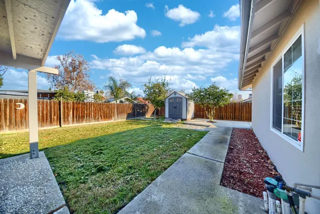 a view of a house with backyard and sitting area
