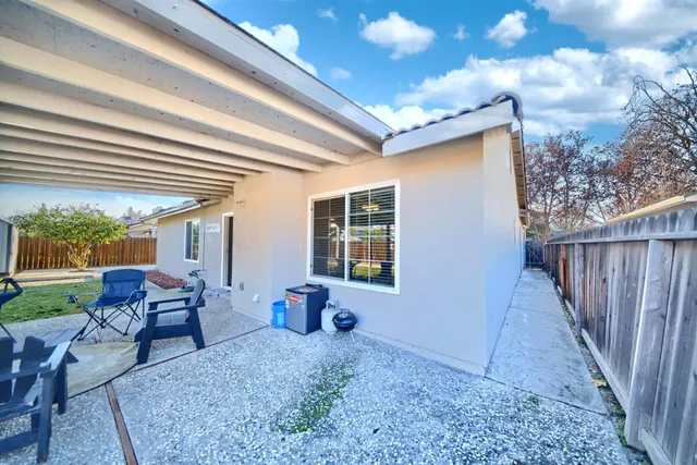 a living room with patio furniture and a floor to ceiling window