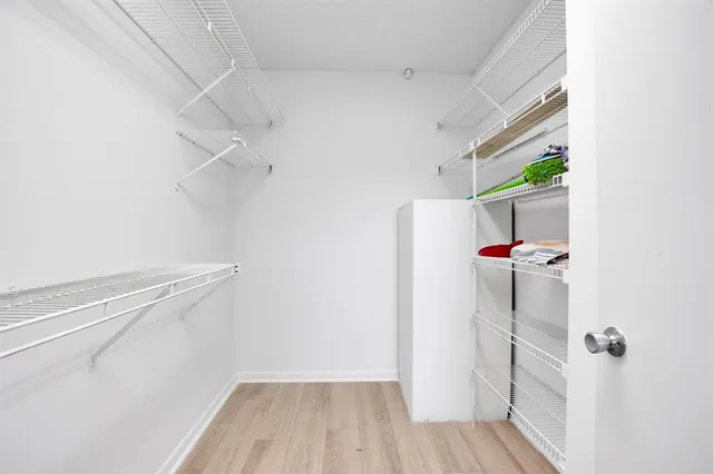 a view of walk in closet with clothes and shoes