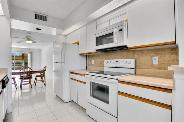 a kitchen with cabinets appliances and wooden floor