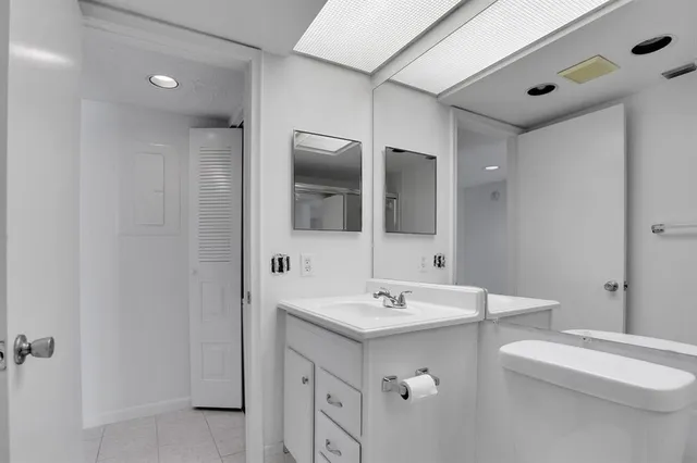a bathroom with a double vanity sink mirror and toilet