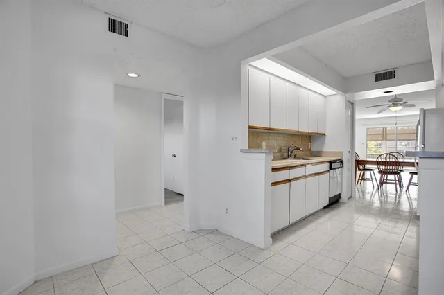 a kitchen with white cabinets and white appliances