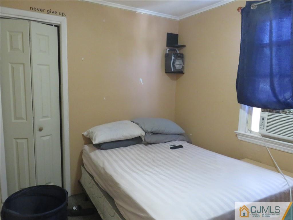 551 Colgate Avenue Perth Amboy, NJ 08861 - Photo 12 of 16 a bedroom with a bed and a cabinets