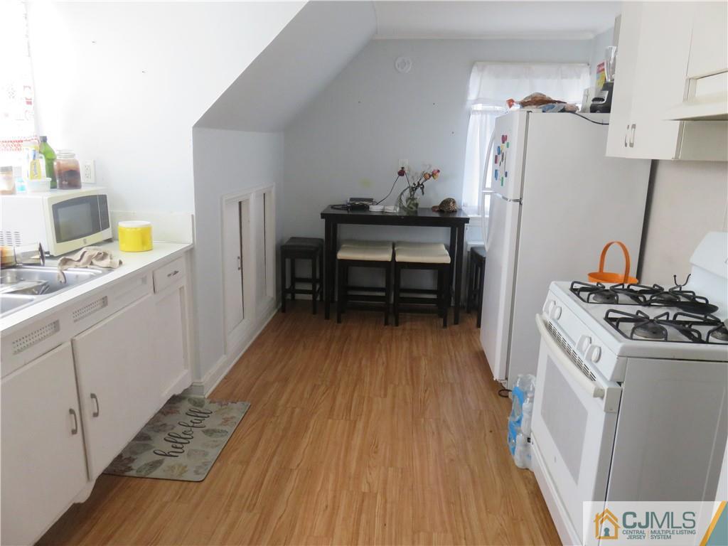 551 Colgate Avenue Perth Amboy, NJ 08861 - Photo 13 of 16 a kitchen with a sink and wooden floor
