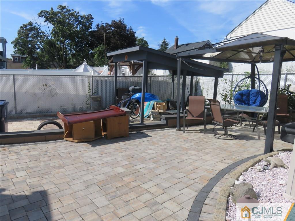 551 Colgate Avenue Perth Amboy, NJ 08861 - Photo 15 of 16 a view of a patio with table and chairs under an umbrella