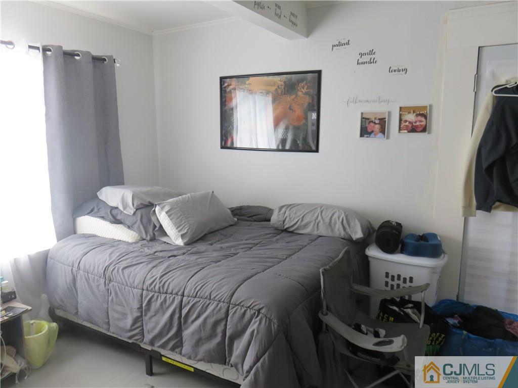 551 Colgate Avenue Perth Amboy, NJ 08861 - Photo 7 of 16 a bedroom with a bed and a flat screen tv