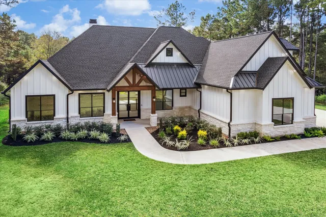 a front view of a house with a garden and plants