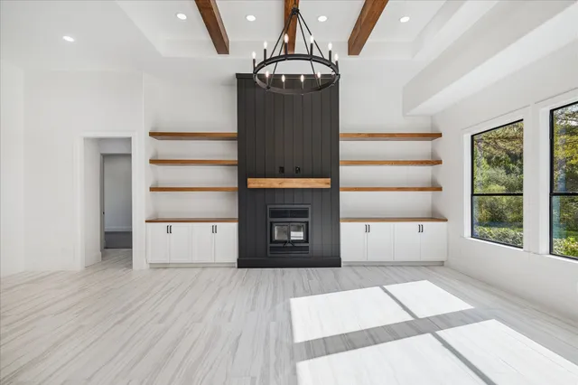 a view of a hallway with wooden floor windows and a kitchen view