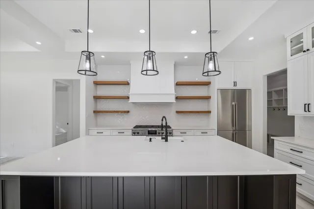 a kitchen with kitchen island a sink stainless steel appliances and cabinets
