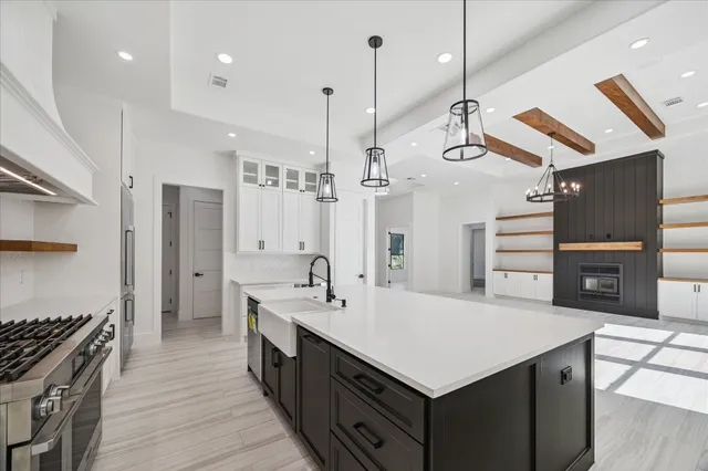 a kitchen with a stove a kitchen island a sink dishwasher a dining table and chairs with wooden floor