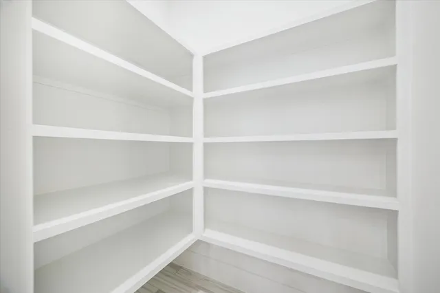 a view of walk in closet with empty racks