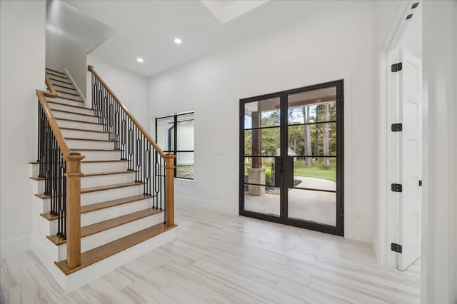 a view of a hallway with wooden floor and windows