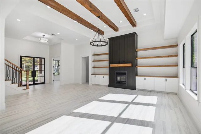 a view of an empty room with a window and fireplace