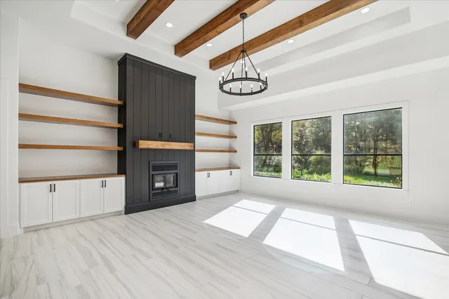 a view of an empty room with a fireplace and a window