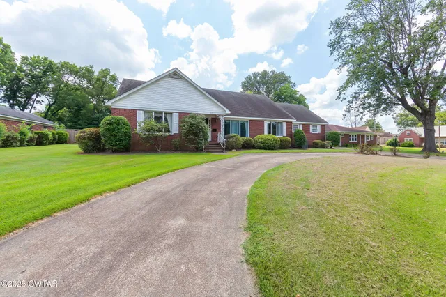 a front view of a house with yard and green space