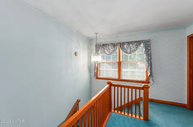 an empty room with window and ceiling fan