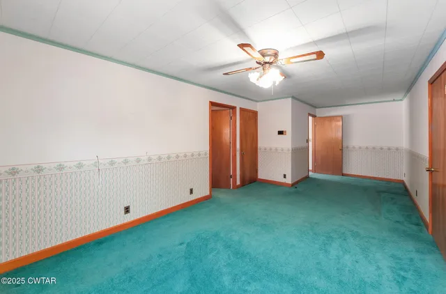 a view of an empty room with a fireplace and window