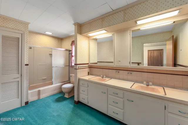 a view of an empty room with a ceiling fan and window