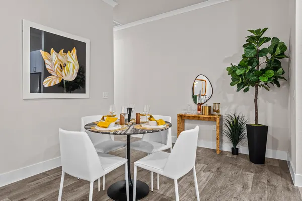 a dining room with furniture and a potted plant