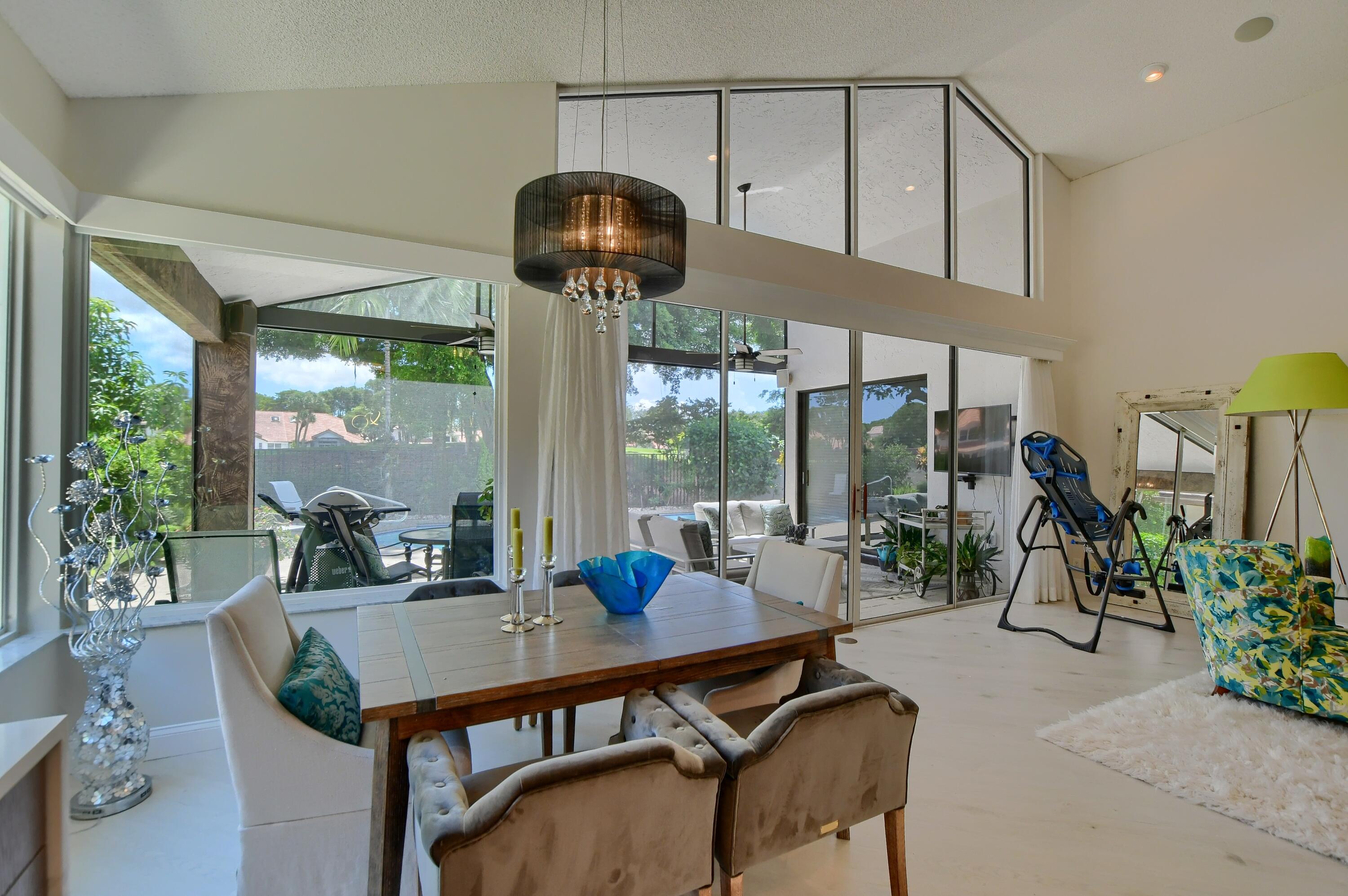 5360 Northwest 20th Avenue Boca Raton, FL 33496 - Photo 12 of 28 a view of a dining room with furniture wooden floor and chandelier