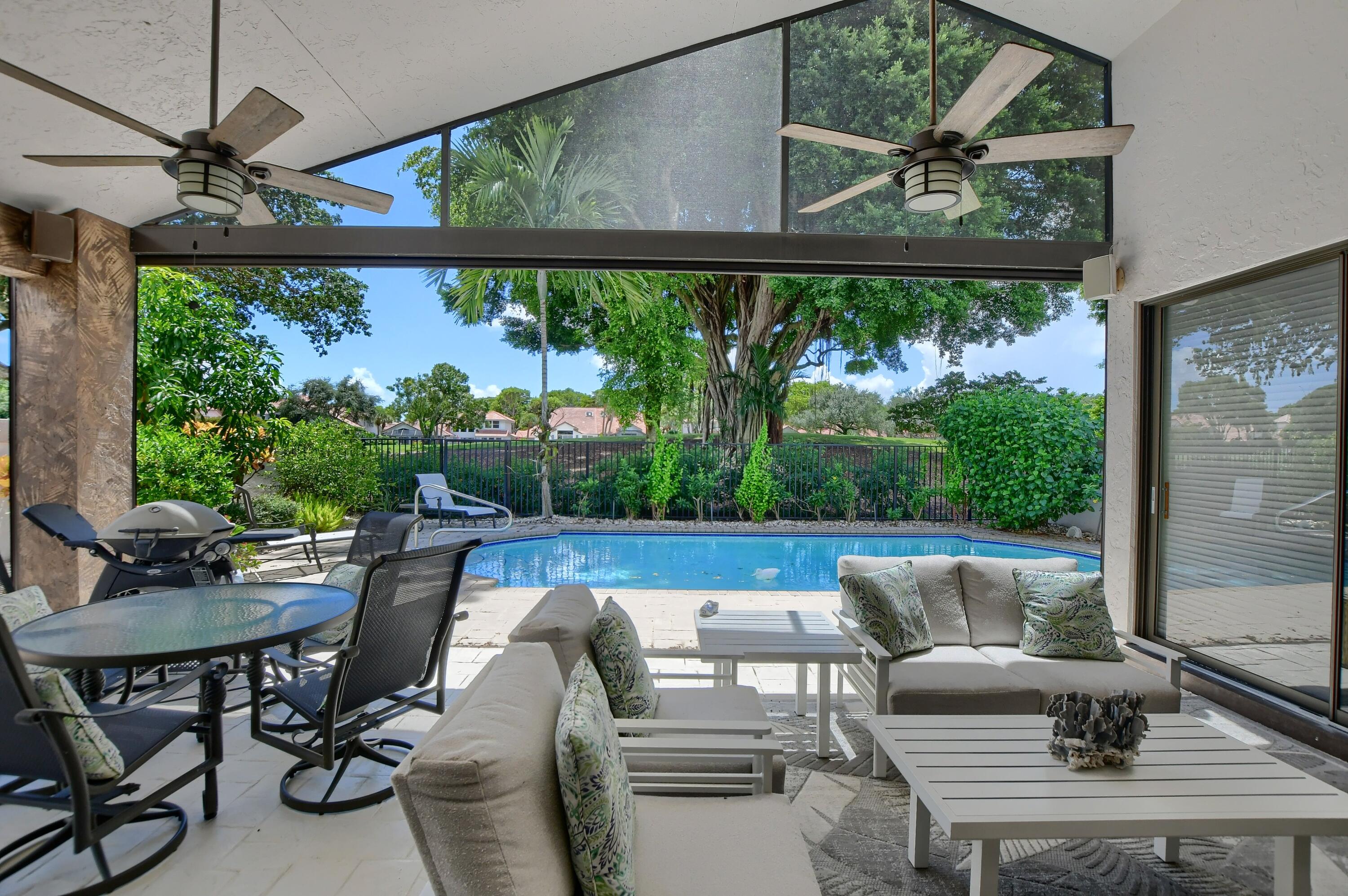 5360 Northwest 20th Avenue Boca Raton, FL 33496 - Photo 19 of 28 a view of a patio with a table chairs and a floor to ceiling window