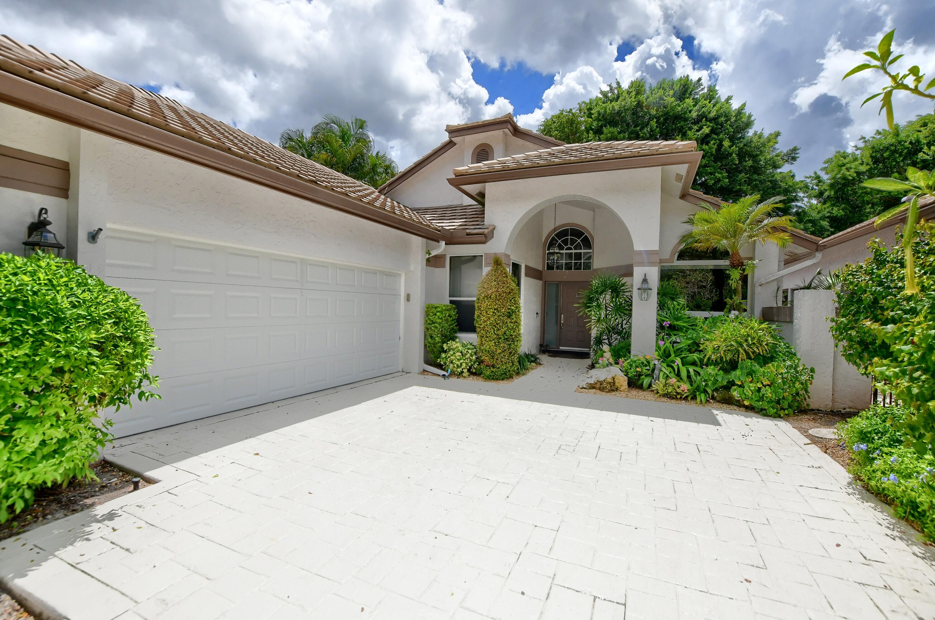 5360 Northwest 20th Avenue Boca Raton, FL 33496 - Photo 2 of 28 a front view of a house with a garden