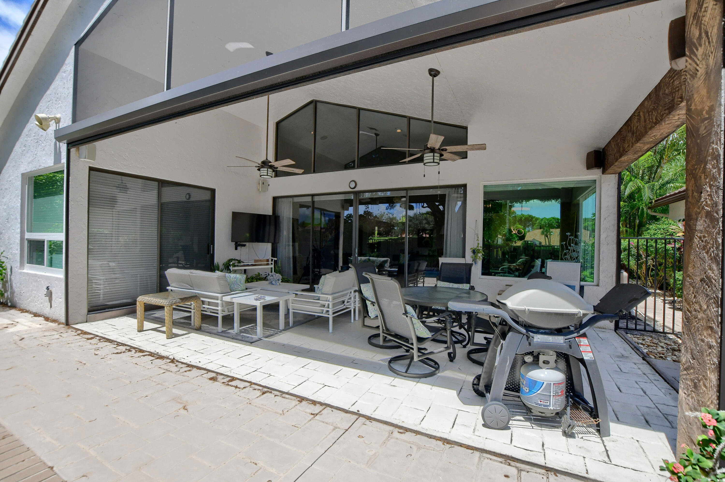 5360 Northwest 20th Avenue Boca Raton, FL 33496 - Photo 22 of 28 a view of a patio with table and chairs potted plants with floor to ceiling window