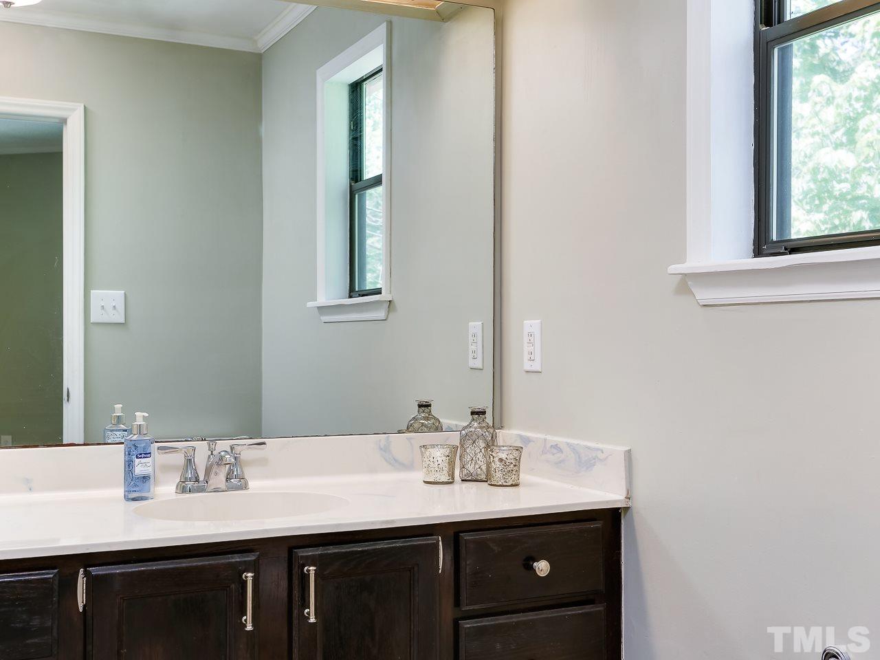 5206 Mountain Ridge Road Raleigh, NC 27612 - Photo 16 of 23 a bathroom with a granite countertop sink and a mirror