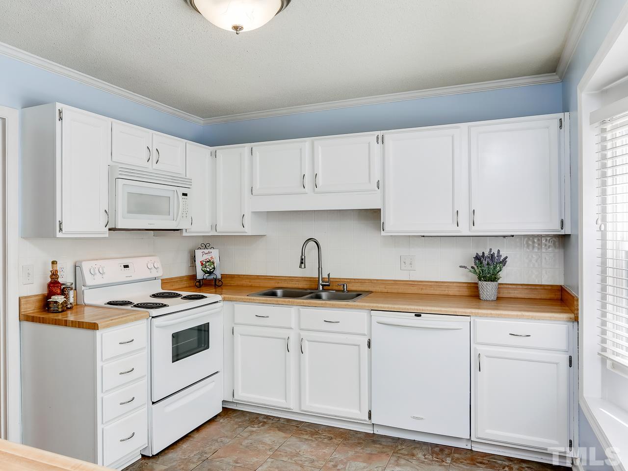 5206 Mountain Ridge Road Raleigh, NC 27612 - Photo 4 of 23 a kitchen with cabinets stainless steel appliances and sink