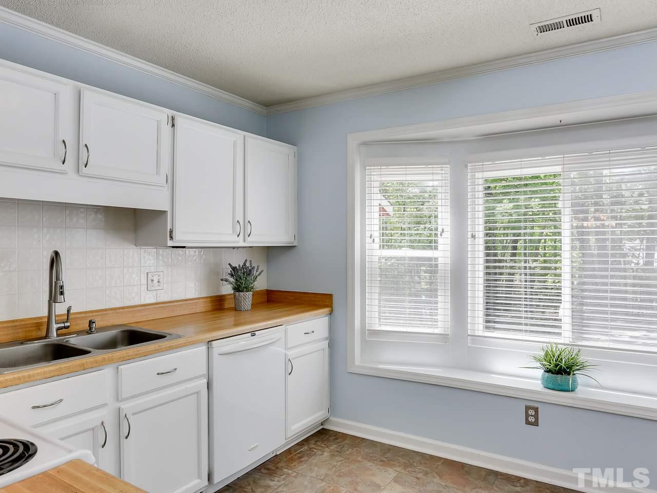 5206 Mountain Ridge Road Raleigh, NC 27612 - Photo 6 of 23 a kitchen with stainless steel appliances white cabinets and a window