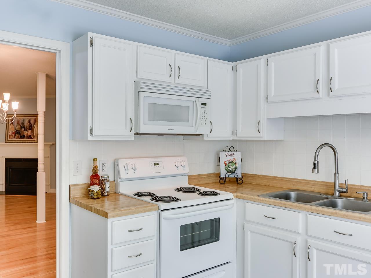 5206 Mountain Ridge Road Raleigh, NC 27612 - Photo 7 of 23 a kitchen with white cabinets and sink
