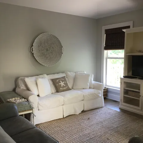 a living room with furniture a flat screen tv and a fireplace