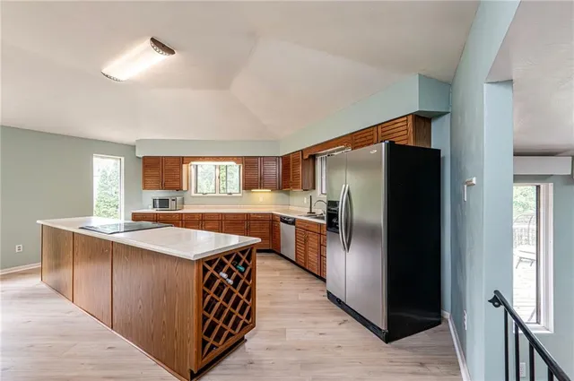 a kitchen with stainless steel appliances granite countertop a refrigerator a sink and a stove