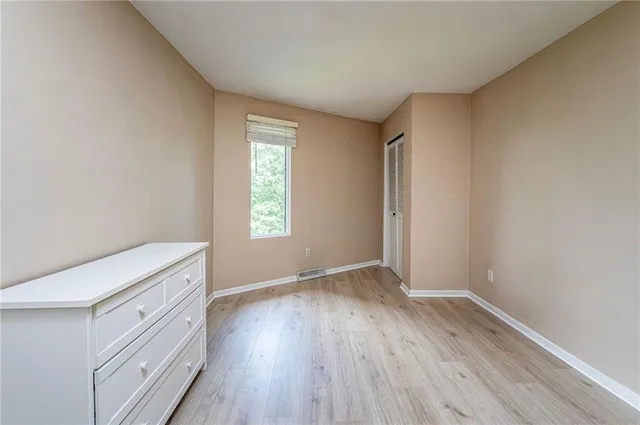 an empty room with wooden floor and window