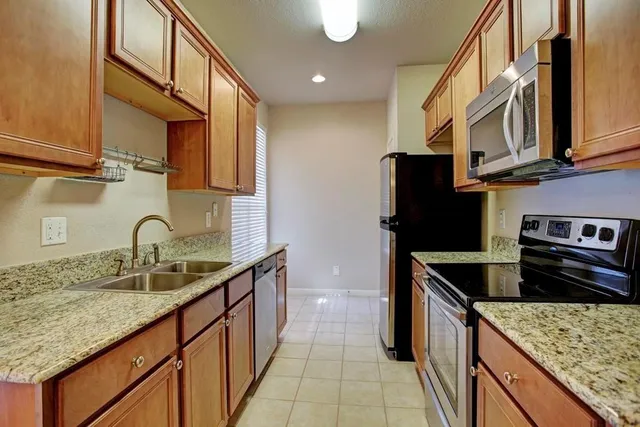a kitchen with stainless steel appliances granite countertop a sink stove and refrigerator