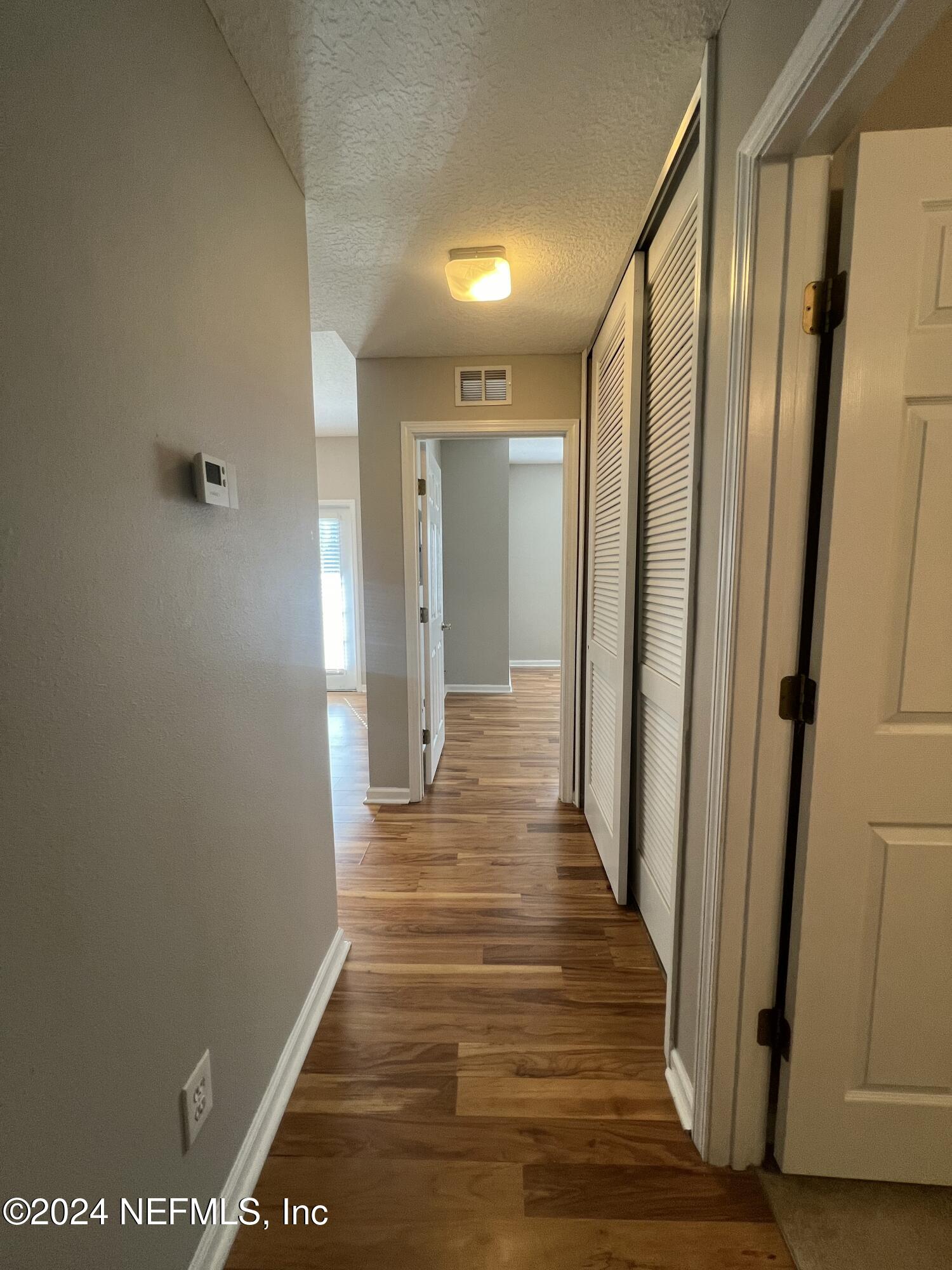 2200 Marsh Hawk Lane, Unit 604 Fleming Island, FL 32003 - Photo 11 of 19 a view of a hallway with wooden floor and staircase